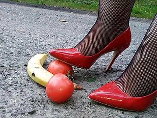 Frau steht auf Bananen und auf rote high Heels